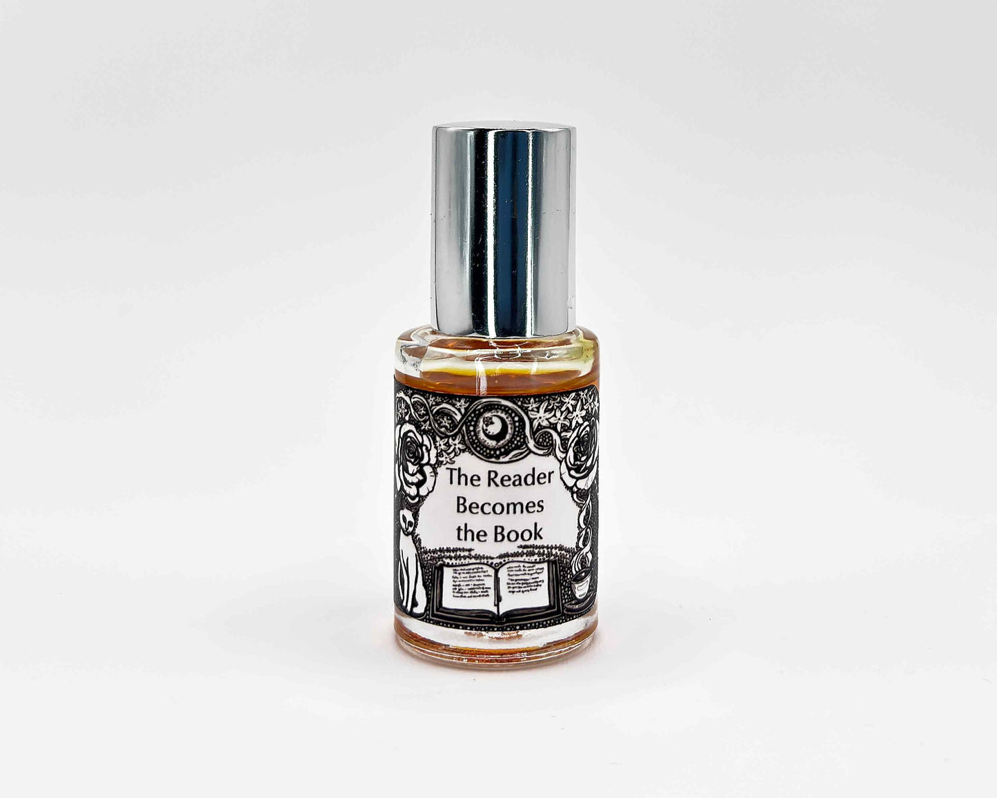 The Reader Becomes the Book Fragrance 5mL bottle. Cylindrical clear glass with Gt Lit Collection artwork label and a cylindrical silver top.