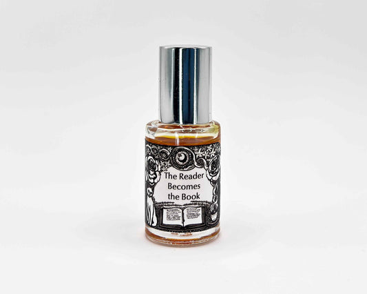The Reader Becomes the Book Fragrance 5mL bottle. Cylindrical clear glass with Gt Lit Collection artwork label and a cylindrical silver top.