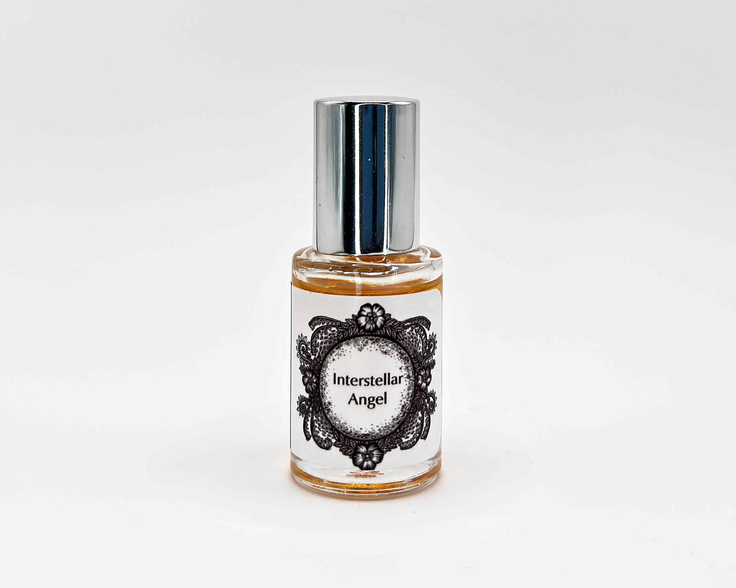 Interstellar Angel Fragrance 5mL bottle. Cylindrical clear glass with Life on the Moon Collection artwork label and a cylindrical silver top.