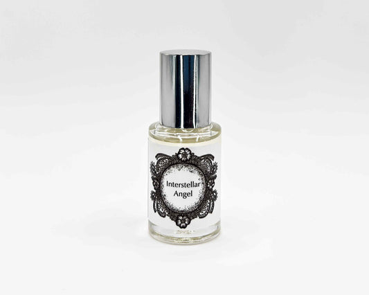 Interstellar Angel Fragrance 5mL bottle. Cylindrical clear glass with Life on the Moon Collection artwork label and a cylindrical silver top.