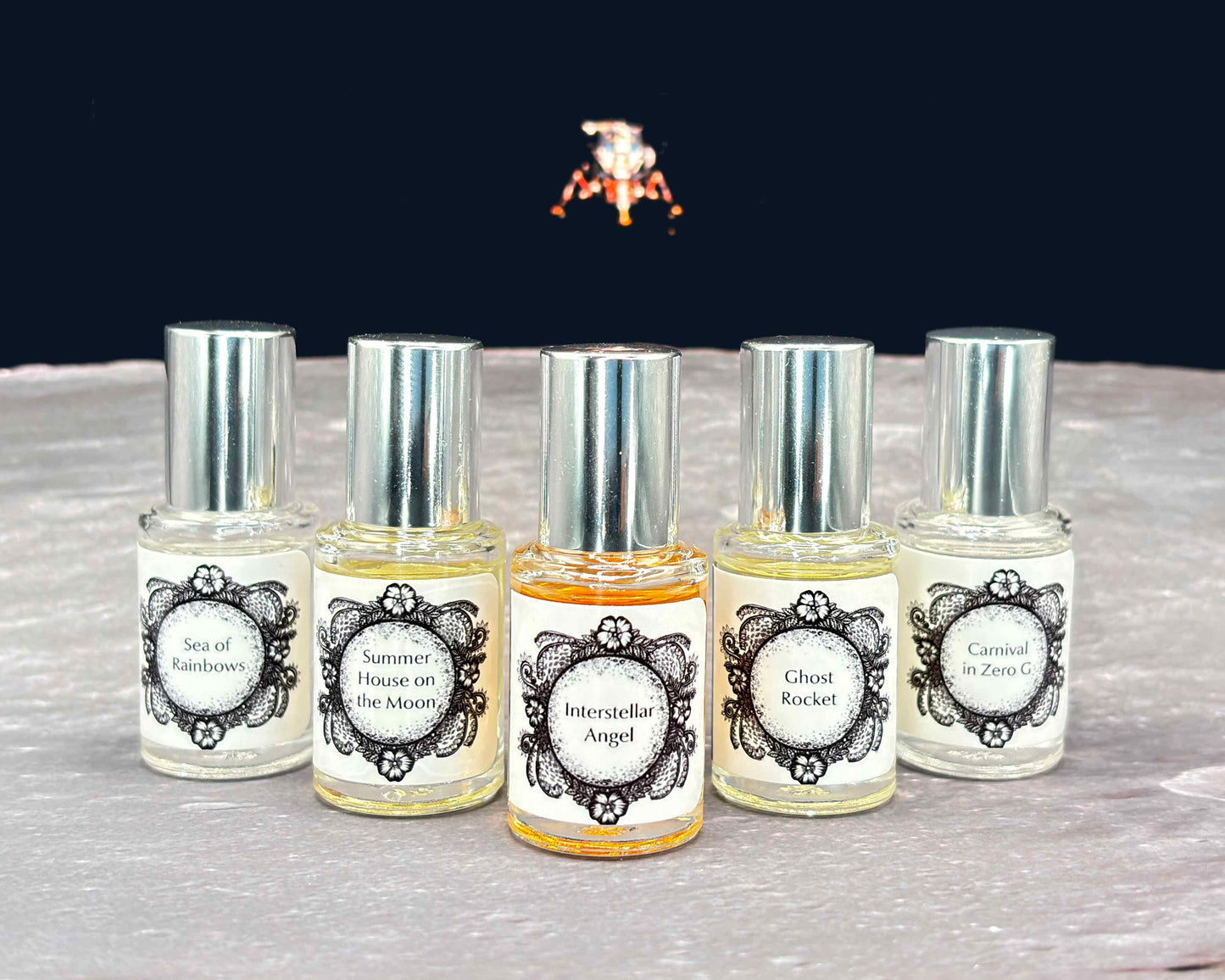 All five Life on the Moon Collection 5 mL bottles lined up on a moonscape with a lunar lander in the background.
