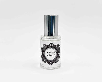 Carnival in Zero G Fragrance 5mL bottle. Cylindrical clear glass with Life on the Moon Collection artwork label and a cylindrical silver top.