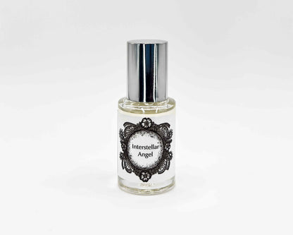 Interstellar Angel Fragrance 5mL bottle. Cylindrical clear glass with Life on the Moon Collection artwork label and a cylindrical silver top.
