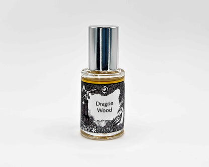 Dragon Wood Fragrance 5mL bottle. Cylindrical clear glass with Lost Fairytale Collection artwork label and a cylindrical silver top.