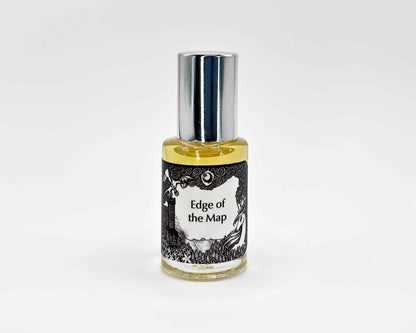 Edge of the Map Fragrance 5mL bottle. Cylindrical clear glass with Lost Fairytale Collection artwork label and a cylindrical silver top.