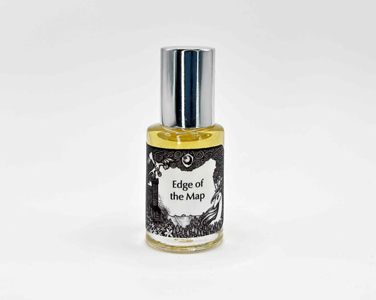 Edge of the Map Fragrance 5mL bottle. Cylindrical clear glass with Lost Fairytale Collection artwork label and a cylindrical silver top.