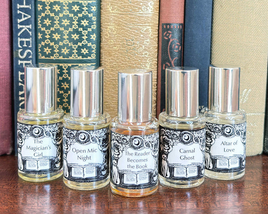 All five Get Lit Collection 5 mL bottles lined up on a wood surface in front of vintage books.