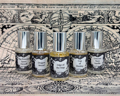 All five Lost Fairytale 5 mL bottles lined up on a vintage map between large white crystals.