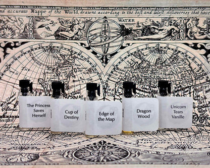 All five Lost Fairytale sample bottles lined up on a vintage map between large white crystals.